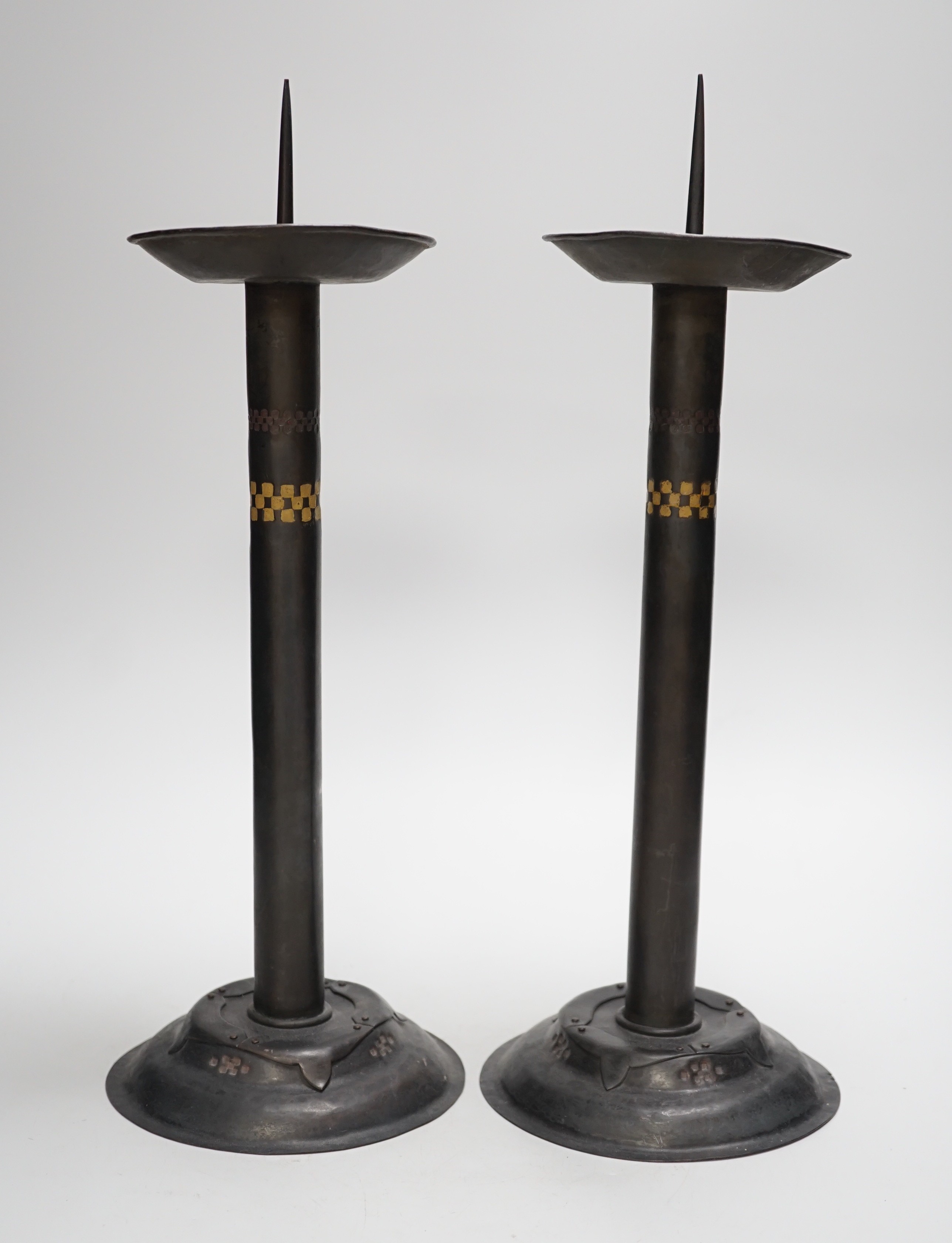 Attributed to Glasgow School of Art - a pair of Arts and Crafts pricket candlesticks. 40cm tall